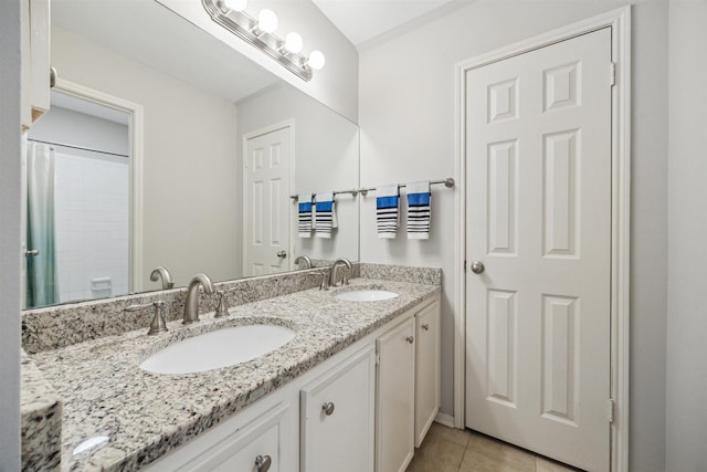 bathroom featuring double vanity, a sink, and tile patterned floors