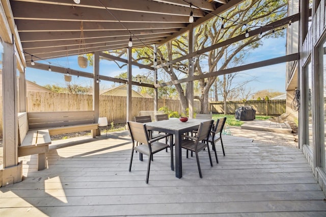 wooden deck with a fenced backyard and outdoor dining area