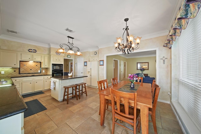 dining room featuring ornamental molding, baseboards, visible vents, and a chandelier