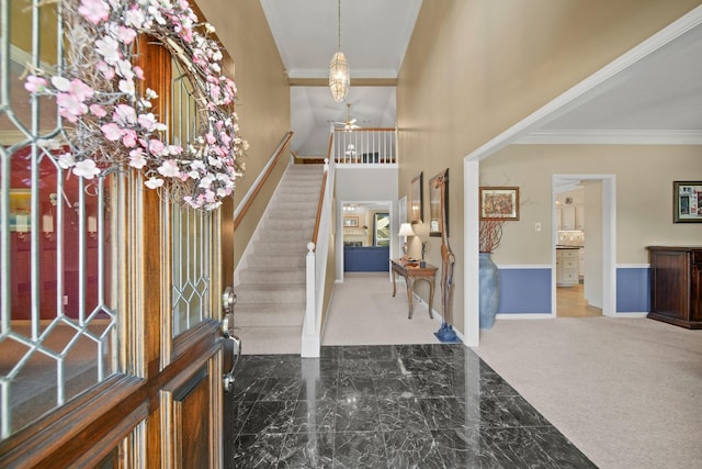 foyer with stairway, baseboards, a high ceiling, crown molding, and marble finish floor