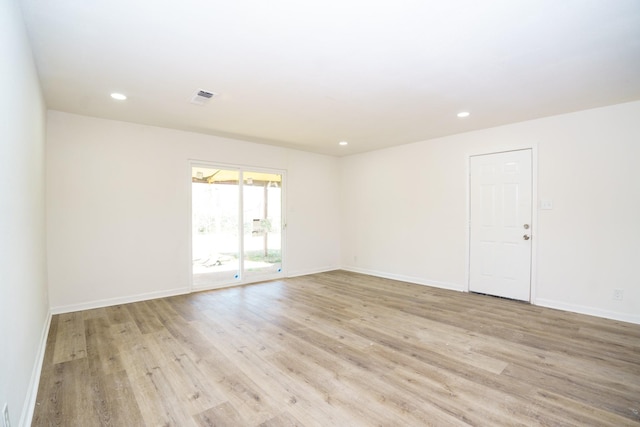 empty room with light wood-style floors, recessed lighting, and baseboards