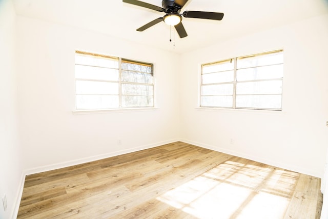 empty room featuring ceiling fan, baseboards, and wood finished floors