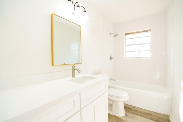 full bath with vanity, shower / bath combination, wood finished floors, and toilet