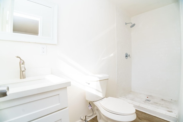 bathroom featuring vanity, a shower stall, and toilet