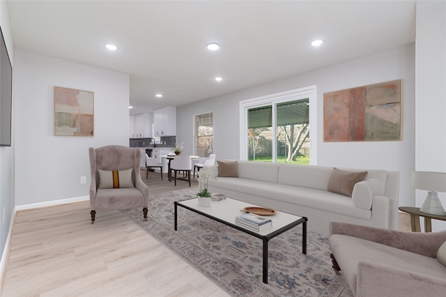 living area with recessed lighting, baseboards, and light wood finished floors