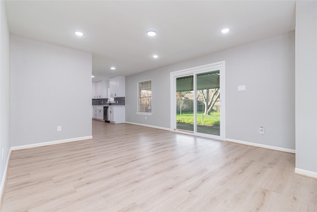 unfurnished living room with light wood-style flooring, baseboards, and recessed lighting