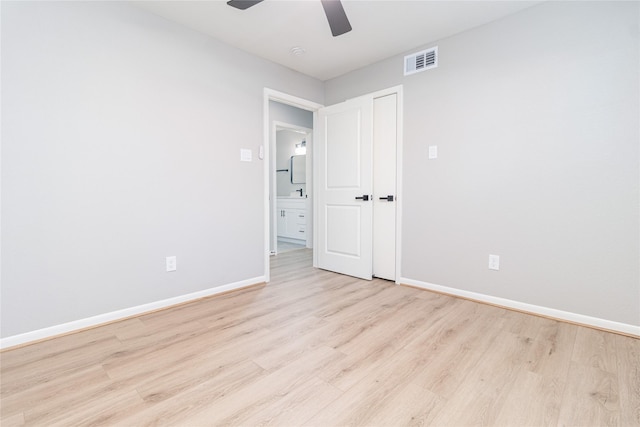 unfurnished room featuring visible vents, light wood-style floors, ceiling fan, a sink, and baseboards