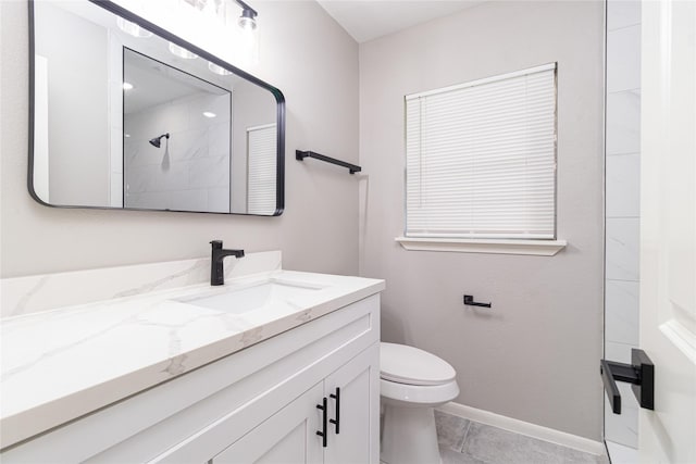 bathroom with toilet, baseboards, a tile shower, and vanity