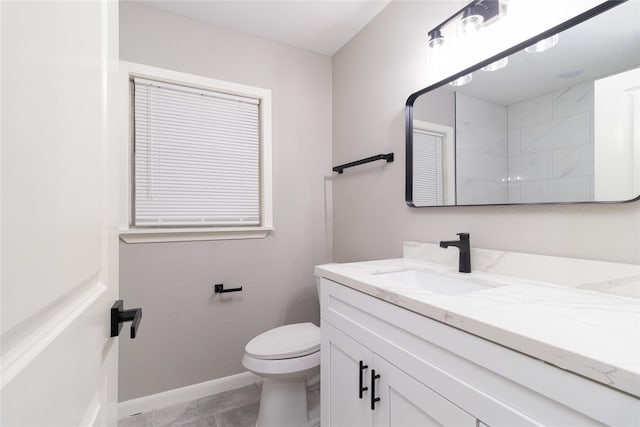 full bath featuring toilet, baseboards, walk in shower, and vanity