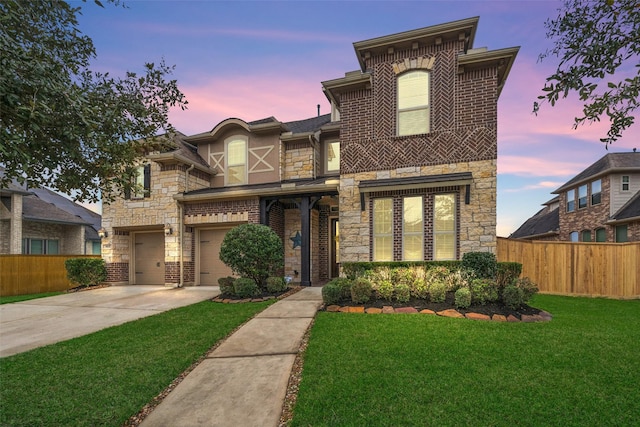 view of front of home with brick siding, concrete driveway, fence, stone siding, and a front lawn