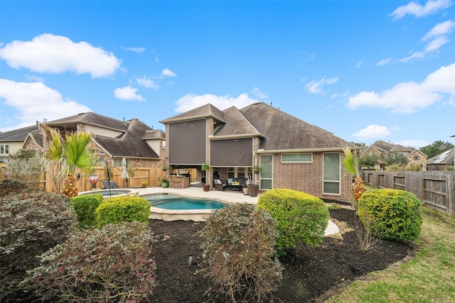 rear view of property with a patio, brick siding, a fenced backyard, and a fenced in pool