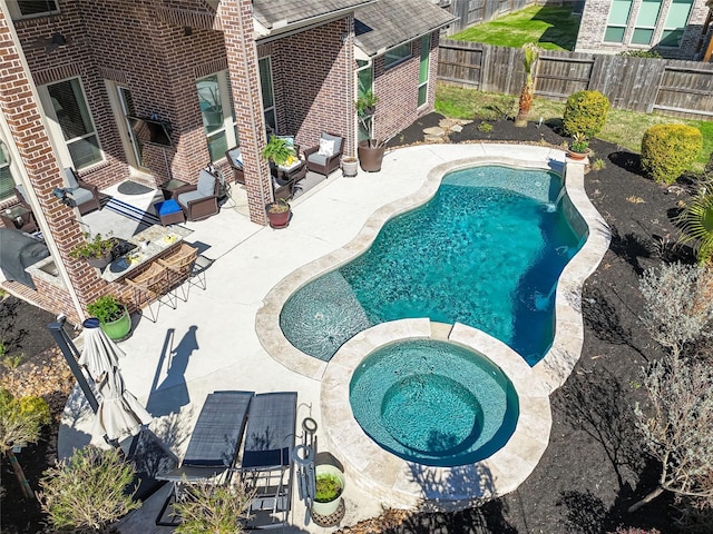 view of pool featuring a fenced in pool, a patio area, a fenced backyard, and an in ground hot tub