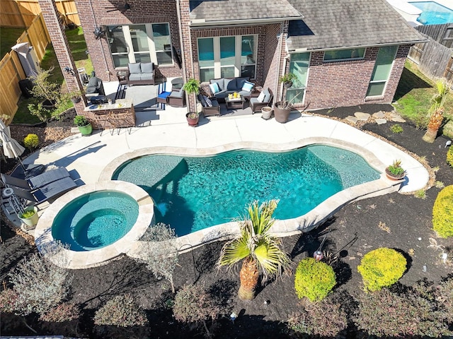 outdoor pool featuring an in ground hot tub, a patio area, a fenced backyard, and an outdoor living space