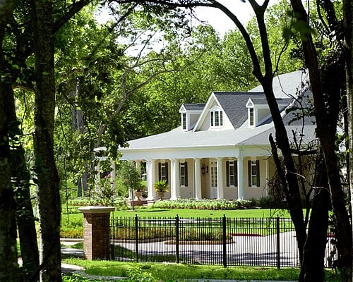 view of front of property with covered porch, a fenced front yard, and a front yard