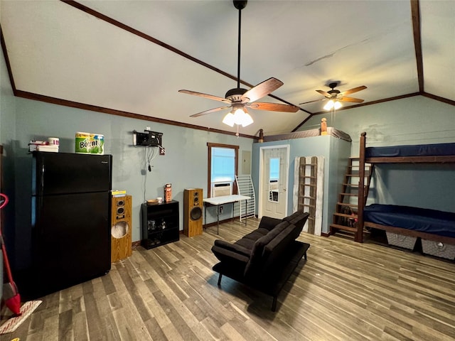 living room with lofted ceiling, ceiling fan, ornamental molding, and wood finished floors