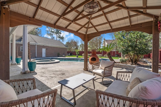 view of patio / terrace featuring a pool with connected hot tub, a fenced backyard, a gazebo, and an outdoor hangout area