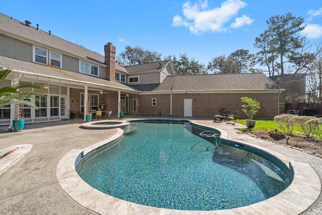 view of swimming pool with a ceiling fan, a pool with connected hot tub, and a patio area