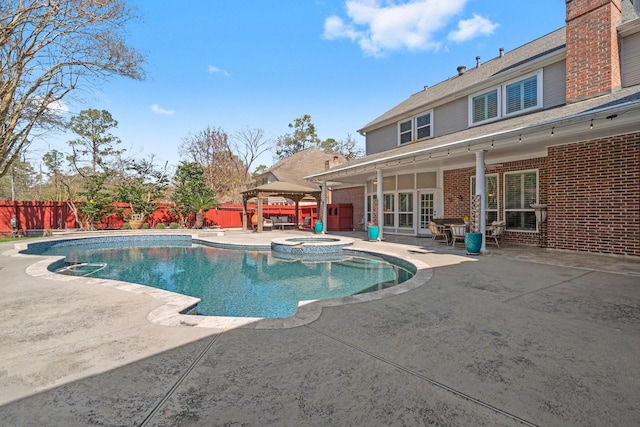 view of pool featuring a fenced backyard, a pool with connected hot tub, and a patio