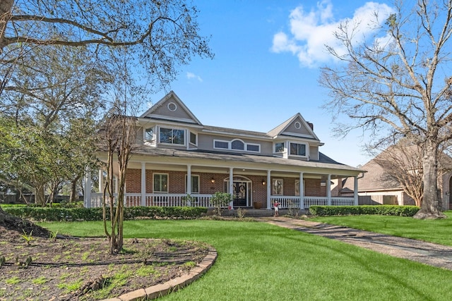 view of front of house featuring covered porch, brick siding, and a front lawn