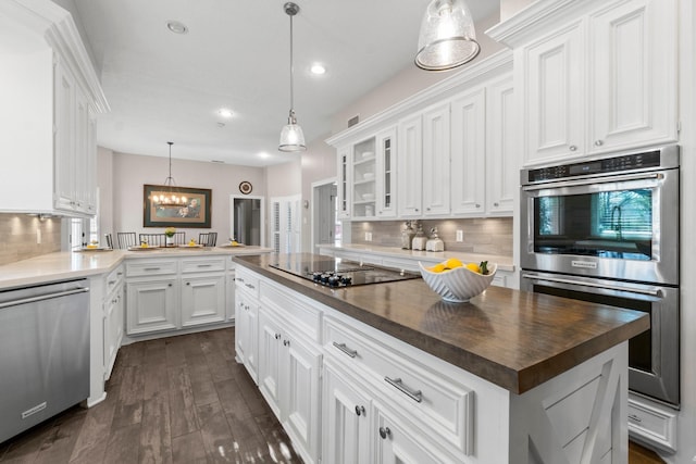 kitchen with a center island, dark wood finished floors, appliances with stainless steel finishes, glass insert cabinets, and white cabinetry