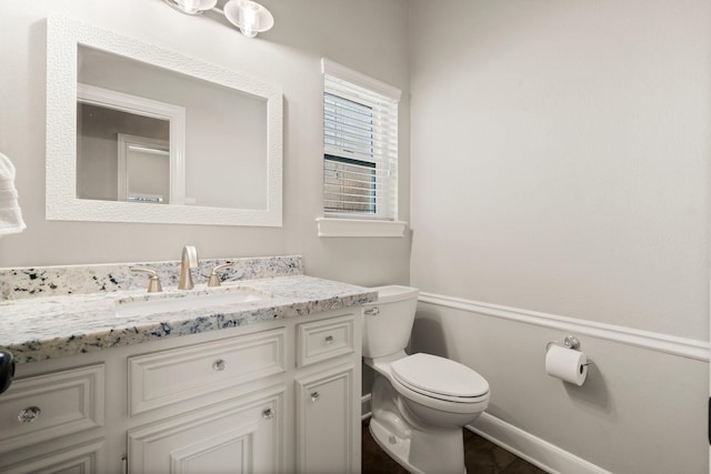 half bath featuring toilet and vanity