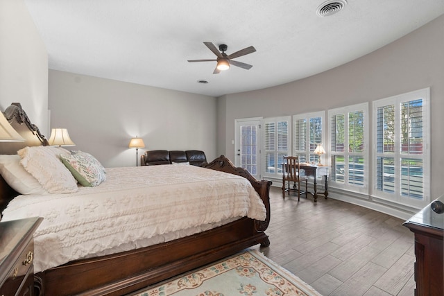 bedroom featuring ceiling fan, wood finished floors, and visible vents