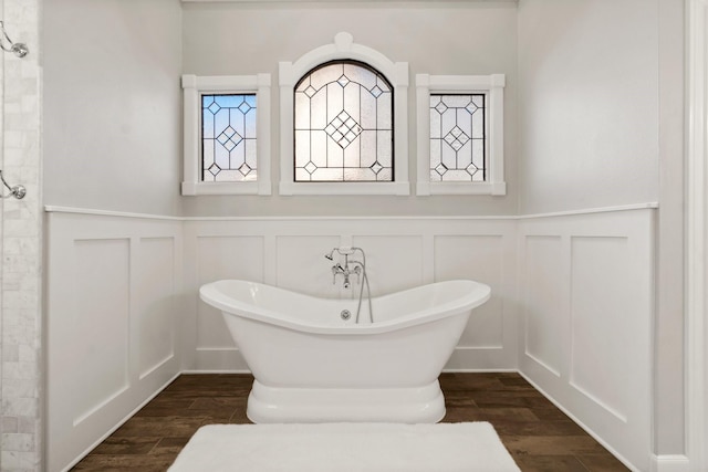 full bathroom with a freestanding tub, tiled shower, a decorative wall, and wood finished floors