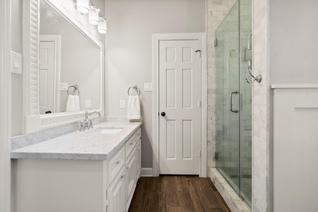 bathroom featuring a shower stall, wood finished floors, and vanity