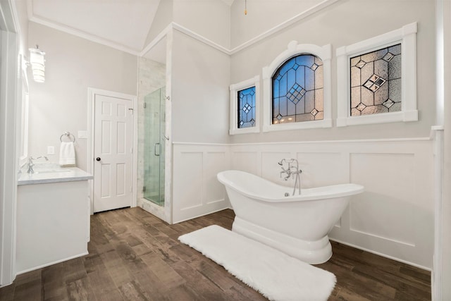 full bath with a stall shower, a freestanding bath, wood finished floors, and a wainscoted wall