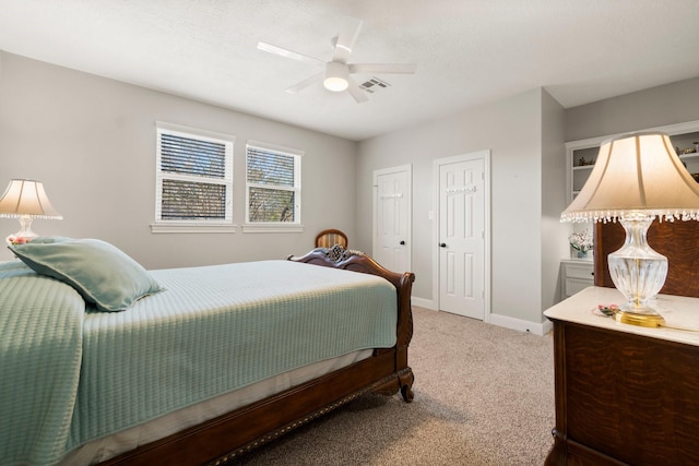 bedroom with light carpet, ceiling fan, visible vents, and baseboards