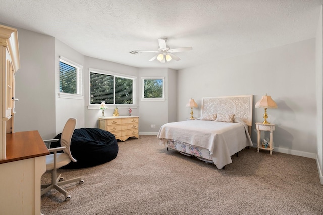 carpeted bedroom featuring a ceiling fan, visible vents, a textured ceiling, and baseboards