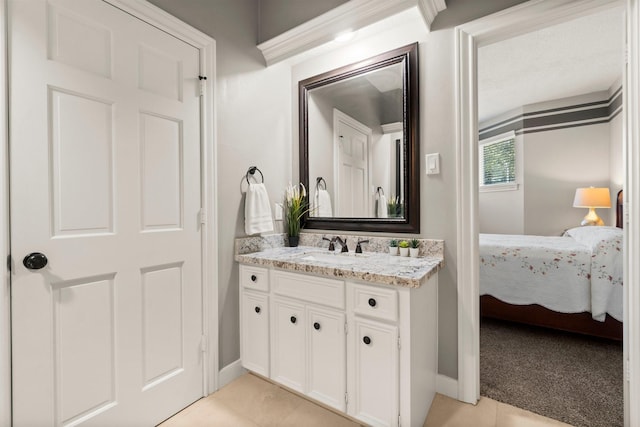 bathroom with ensuite bath, baseboards, tile patterned flooring, and vanity