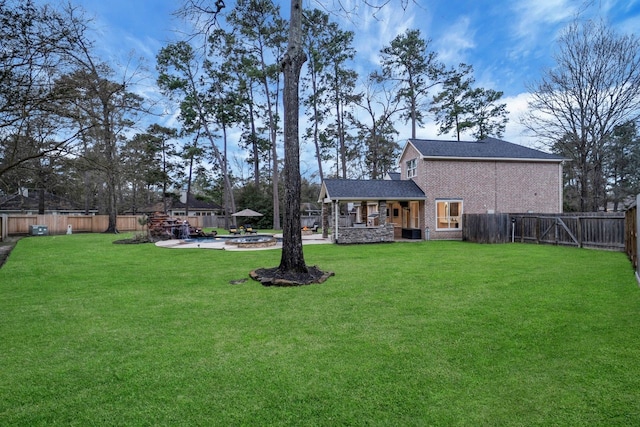 view of yard with a patio area, a fenced backyard, and a fire pit