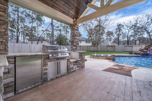 view of patio / terrace featuring a grill, a fenced in pool, an outdoor kitchen, and a fenced backyard