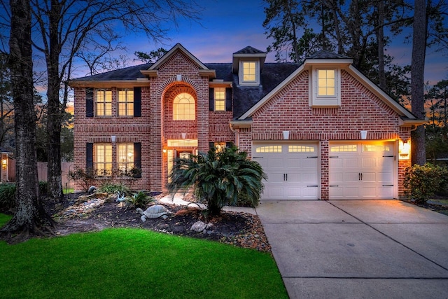 traditional-style house with a garage, concrete driveway, and brick siding