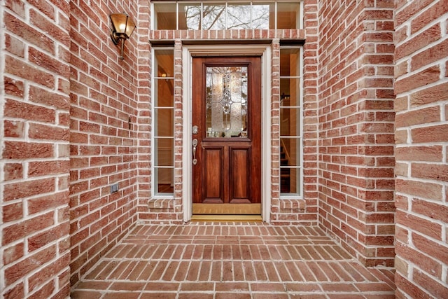 view of exterior entry with brick siding