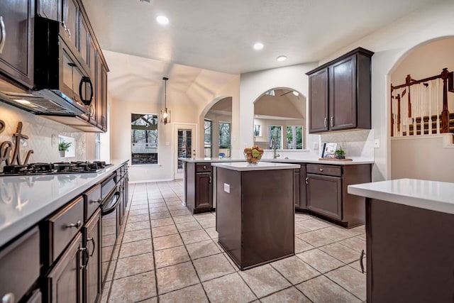 kitchen with a kitchen island, stainless steel gas cooktop, light countertops, and a sink