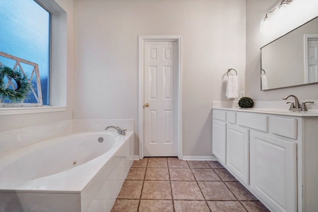 bathroom featuring baseboards, a jetted tub, vanity, and tile patterned floors