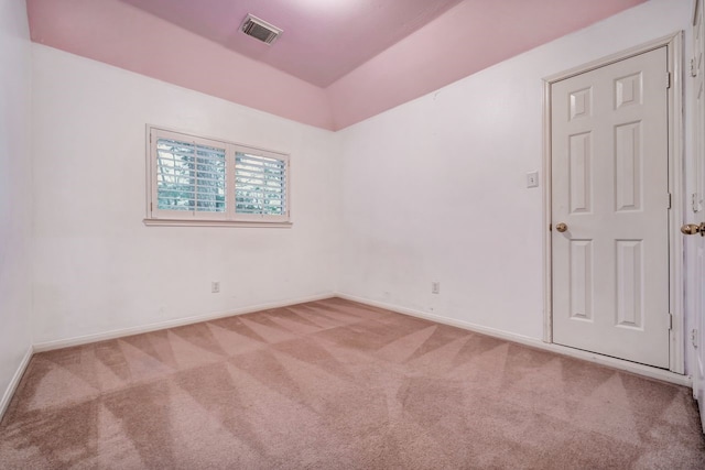 spare room featuring carpet, visible vents, and baseboards