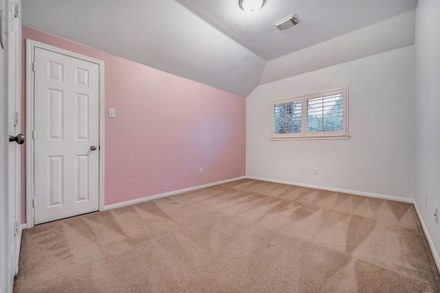 additional living space featuring carpet, visible vents, lofted ceiling, and baseboards