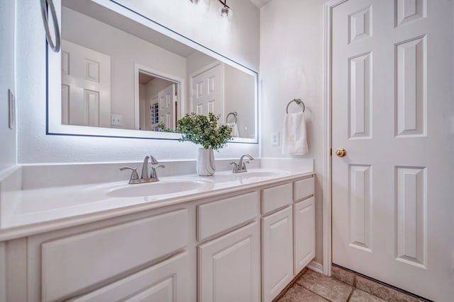 bathroom featuring tile patterned flooring, a sink, and double vanity