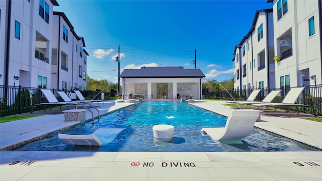 community pool with a patio area and fence