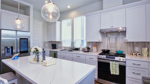 kitchen with under cabinet range hood, a sink, white cabinetry, appliances with stainless steel finishes, and backsplash