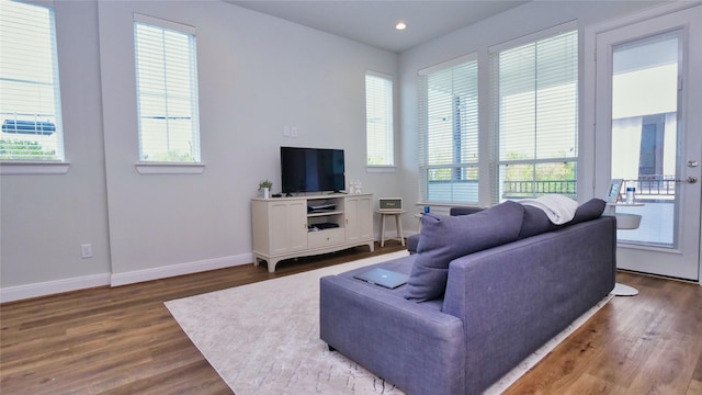 living room featuring dark wood-type flooring, recessed lighting, and baseboards