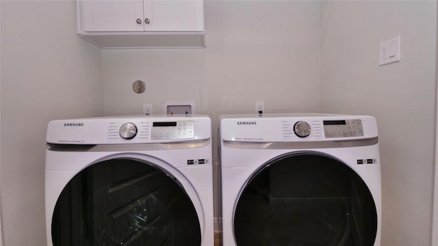 clothes washing area with cabinet space and washer and dryer