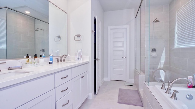 bathroom featuring a relaxing tiled tub, tile patterned flooring, a sink, and tiled shower