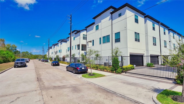 view of street featuring sidewalks, a residential view, curbs, and street lights