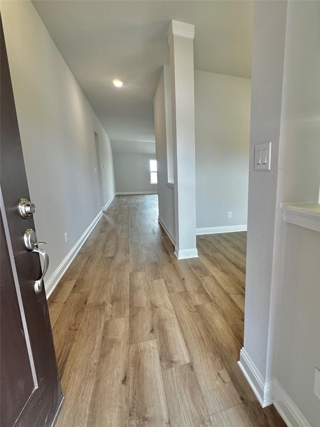 corridor featuring wood finished floors and baseboards