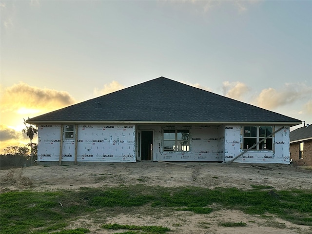 unfinished property featuring a shingled roof