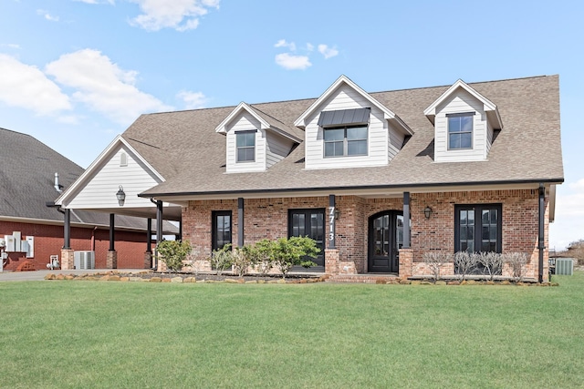 view of front of home featuring a front yard, cooling unit, and brick siding